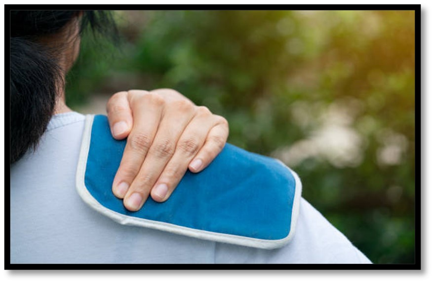 A heating pad held against a shoulder
